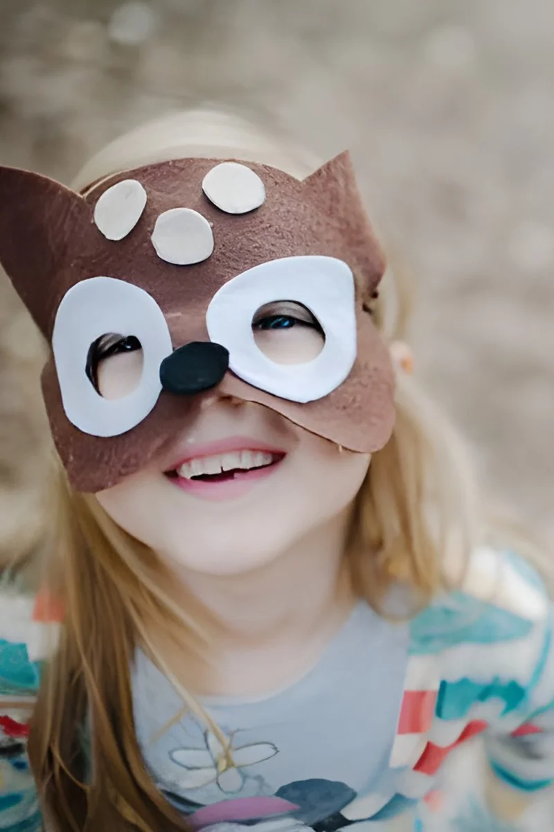 Preschooler in a handmade felt mask during imaginative play at Sunshine Mini School